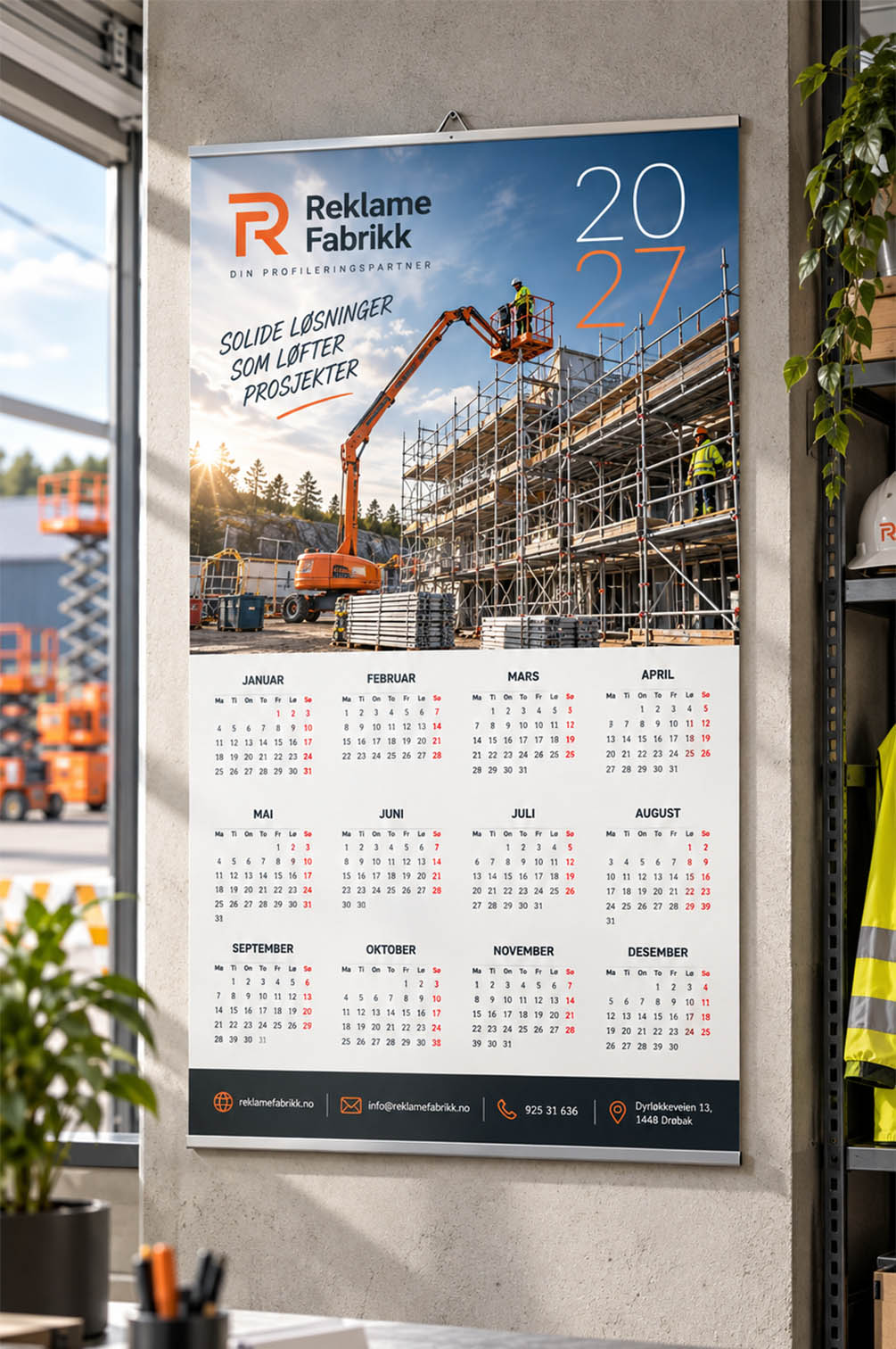 Veggkalender for stillas og liftutleie – firmakalender 2027 Firmakalender 2027 med stillas, bomlift og arbeidere på byggeplass